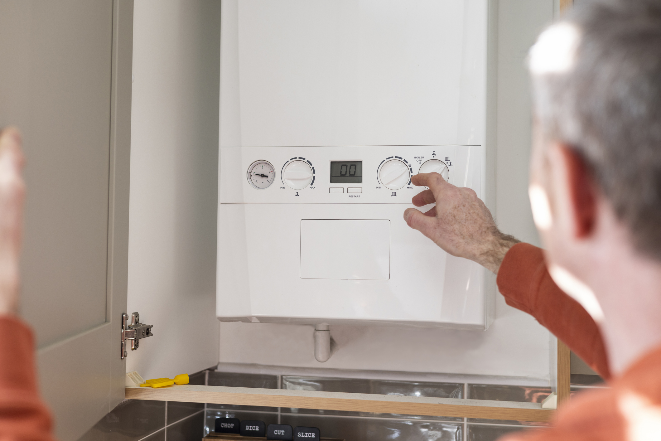 Man adjusting the controls of his boiler