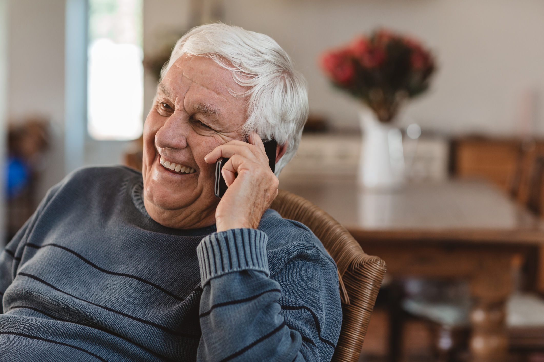 Older man cheerfully talking on his phone