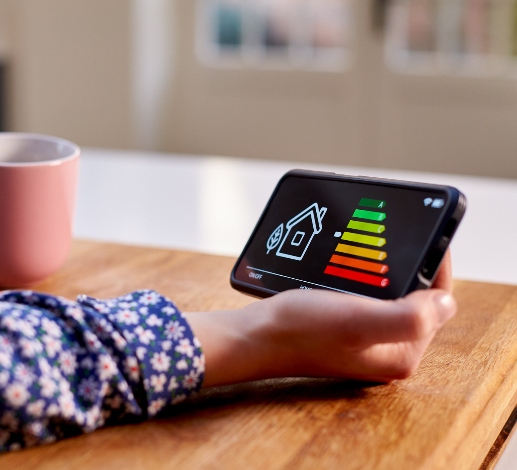 Person holding a smart meter and a cup of coffee